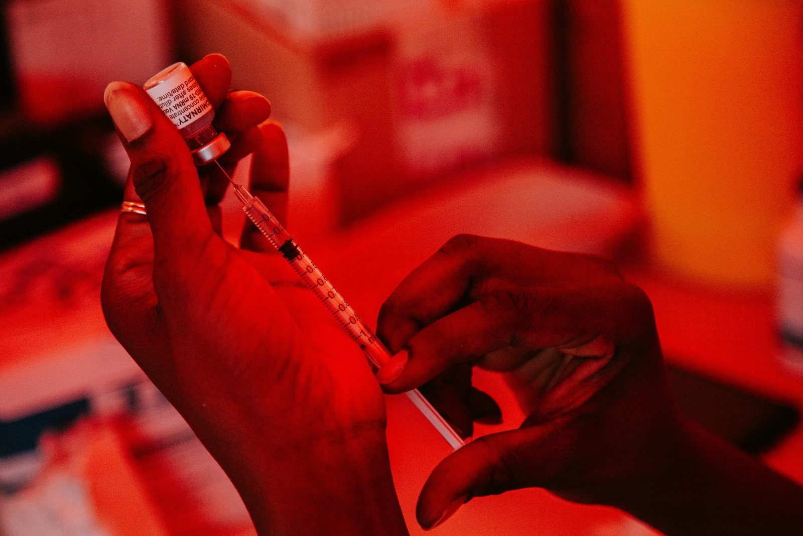 person holding white and black labeled bottle scaled